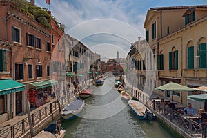 VENICE, ITALY Ã¢â¬â MAY 23, 2017: Traditional narrow canal street with gondolas and old houses in Venice, Italy.